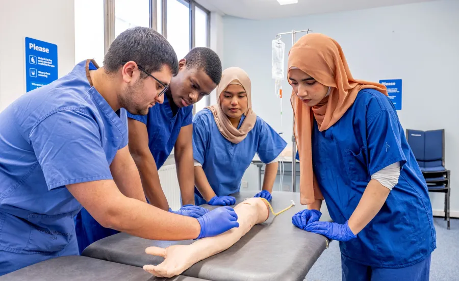 Fahmia and other student doctors studying an arm