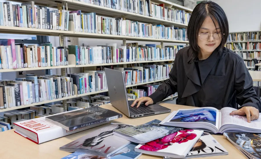 A woman reading fashion books in the WSA library