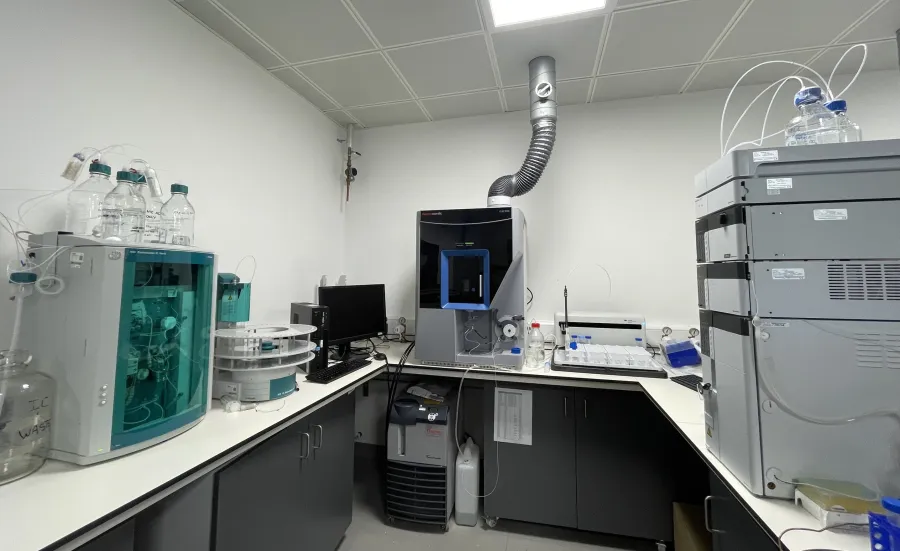Analytical area at the environmental laboratory with advanced scientific instruments, computer monitor, and exhaust pipe