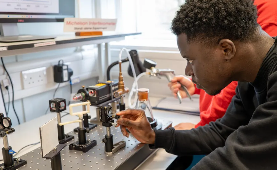 Physics student looking at machinery