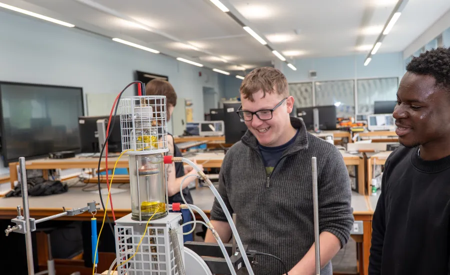 Students working with experimental equipment in a physics laboratory.