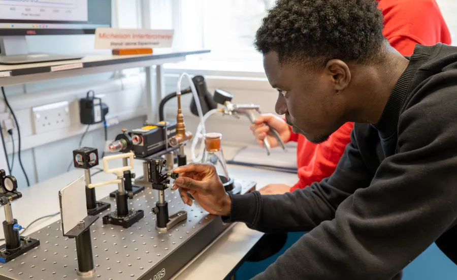A physics student engaging with lab work