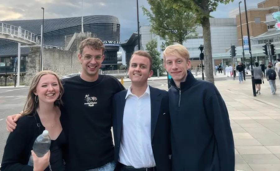 Daniel (second from the right) stands with arms around 3 friends he made on his course