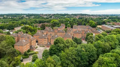 Wessex Lane halls viewed from City Gateway. A cluster of red brick halls surrounded by lush green trees on a sunny day