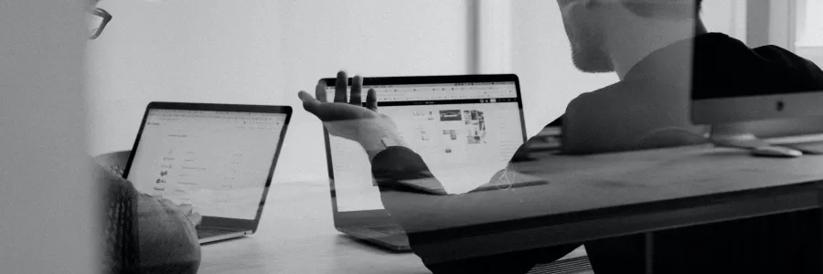 People working on laptops, seen through glass