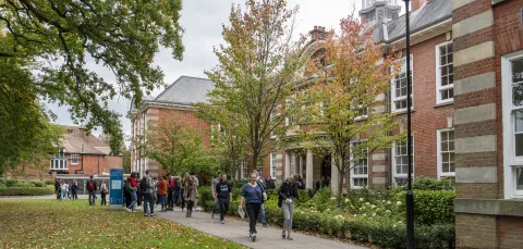 Students outside main building of Avenue Campus on spring day.