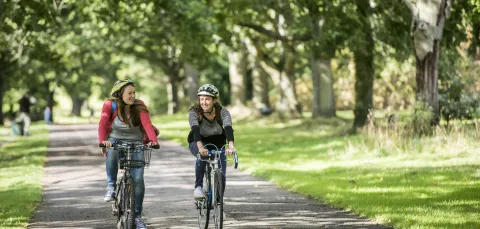 Students cycling on Southampton Common on sunny day.