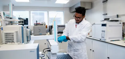 A student conducting an experiment at a test bench in a laboratory