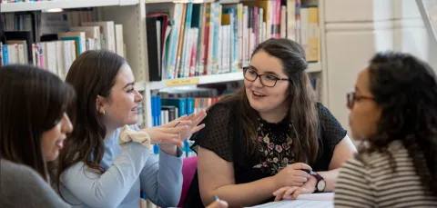 Group of history students in discussion in a library setting