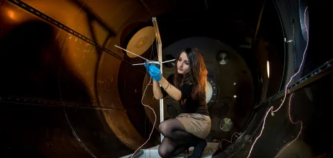 A student checks their experiment in the electric propulsion lab