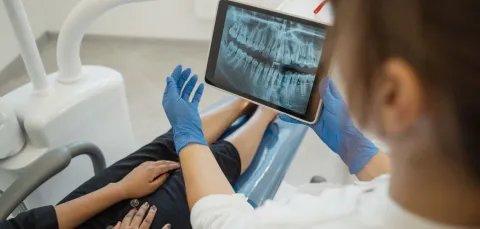 Dental professional and client in a consultation looking at an xray