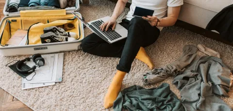 An international student packs their bag, including their passport, to come to the UK