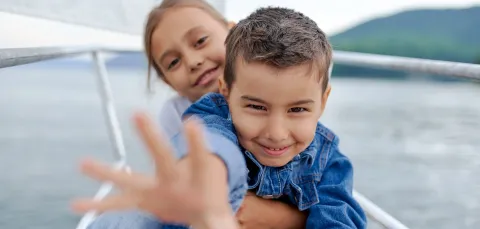 Close of two happy looking young children on a yacht