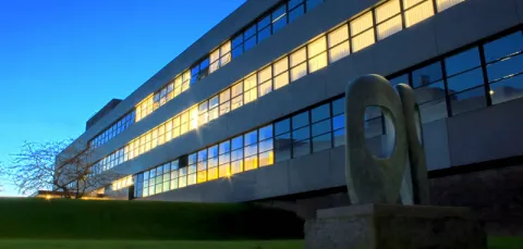 Highfield campus building 46 at dusk with lights shining from the windows