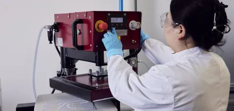 A woman researcher using a machine at the e-textile laboratory