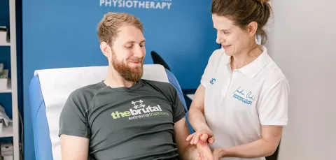 A physiotherapist examining a clients arm