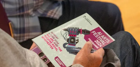 View of the AI Arts Festival magazine in a lap