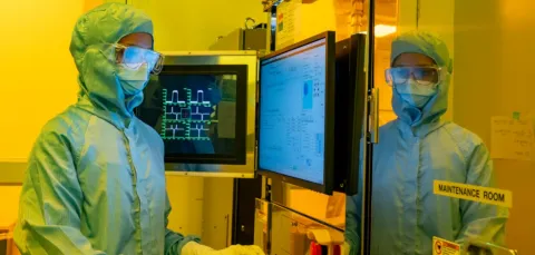 A woman standing in front of electron beam lithography tool control