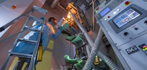 A man standing on a ladder in front of 4-metre drawing tower