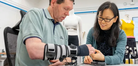 A patient wearing a forearm support receives therapy on his hand