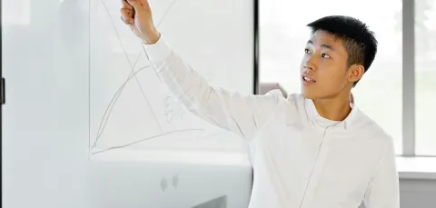 A young man animatedly gestures to a graph