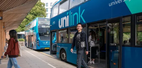 A student alighting a double decker bus at the University of Southampton's Highfield campus.