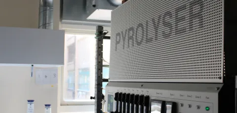 A laboratory machine with switches and indicator lights beneath it.