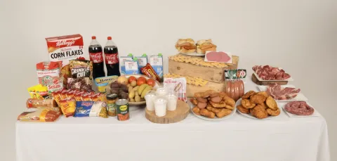 A table displaying a wide range of foods, including fresh produce, dairy, packaged snacks, and raw meats.