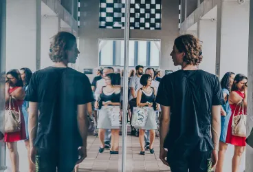 Man looking at his reflection in a window