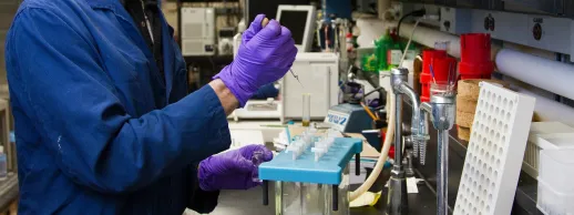 A scientist injects a test tube with fluid
