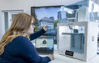 A student inspecting the finished construction of her latest 3D printed object.
