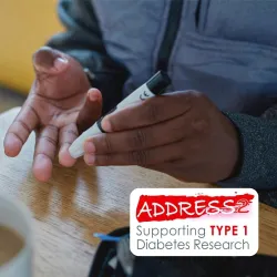Person using a glucose meter on their fingertip beside a cup of coffee and biscotti on a table.