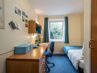 A bright, airy student bedroom with desk and single bed.