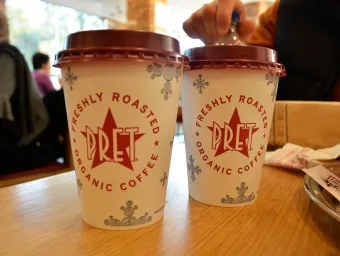 Close up of 2 Pret a Manger coffee cups on a table.