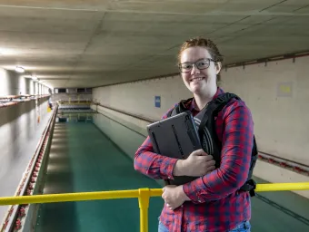 Student smiling to camera with towing tank behind her.