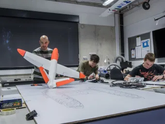 Students working with plane models in UAV research lab. 