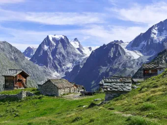 Looking across green fields towards the peaks of the Arolla mountains