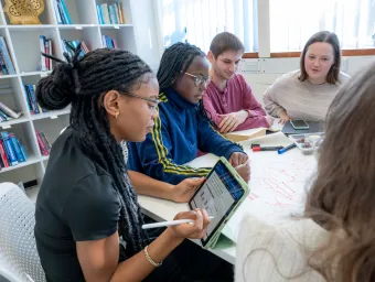Ria Moses in a group meeting holding an iPad