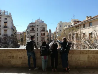 Beth and 3 of her fellow students, on a balcony looking out at Alicante buildings.