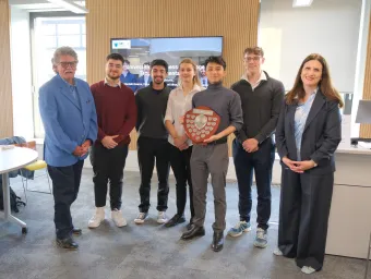 Undergraduates from the Southampton Business School standing in a line with the winners shield at the 2025 Universities Business Challenge.