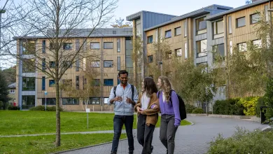 Three students walking outside halls of residence