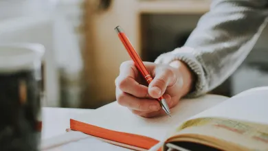 A hand writing in a book.
