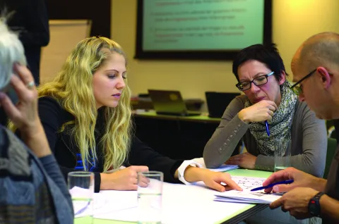 4 people around a table looking at a document