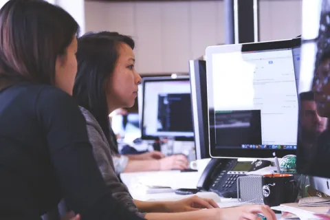 2 women looking at computer screens