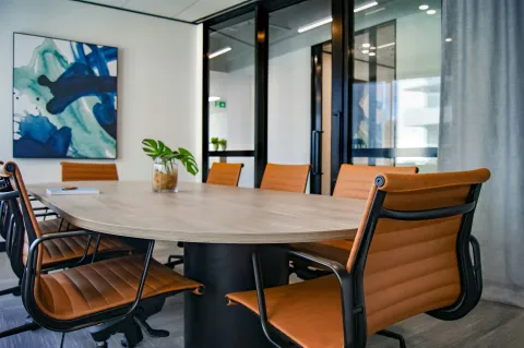 An empty boardroom with brown leather chairs