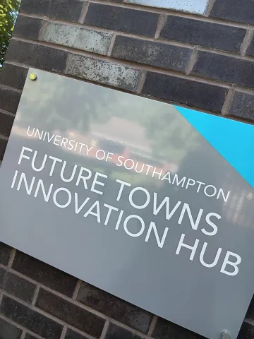 Sign reading "University of Southampton Future Towns Innovation Hub" on a brick wall.
