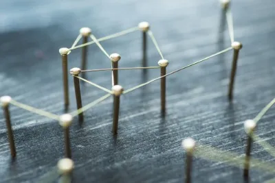 Pins in a board with string tied around from 1 pin to another