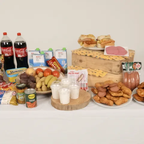 A table displaying a wide range of foods, including fresh produce, dairy, packaged snacks, and raw meats.
