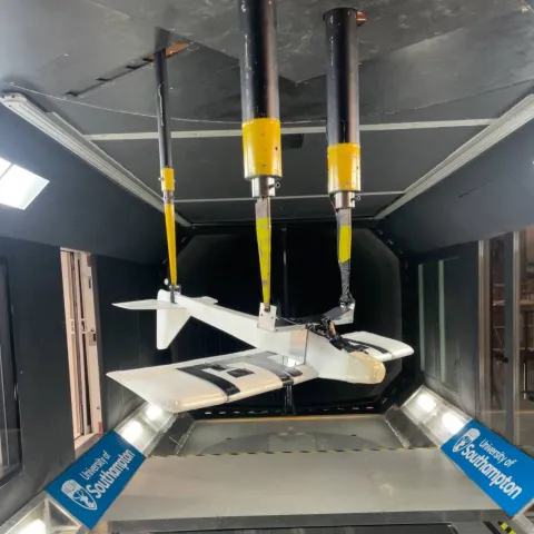 A model aircraft hangs inverted inside a wind tunnel at the University of Southampton.