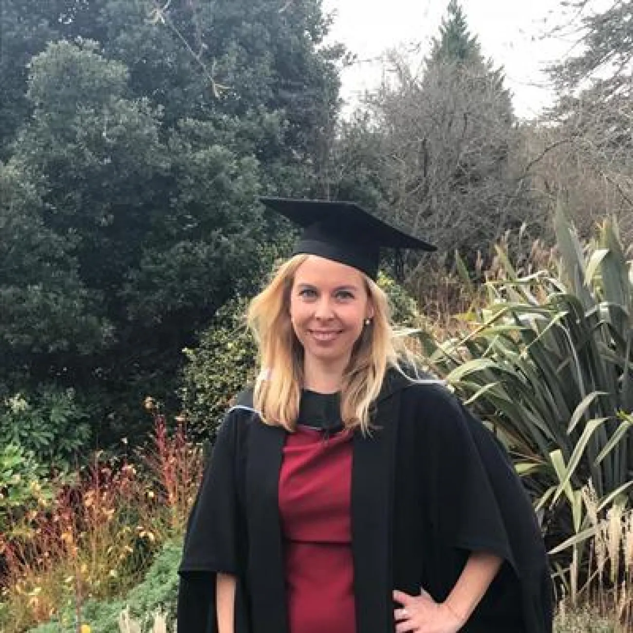 Dr Jess Jarvis smiles at the camera in her graduation gown and cap